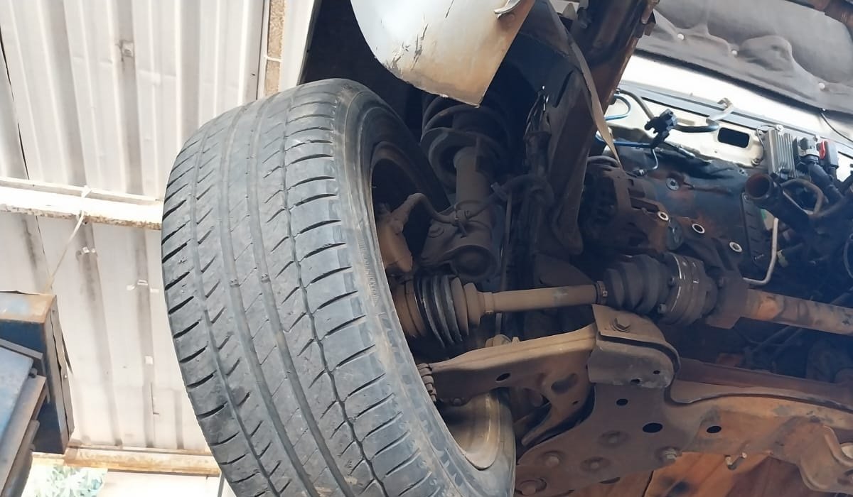 Suspensão e pivos de uma das rodas do carro levantado no elevador