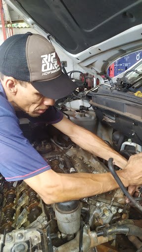 Mecânico Marcelo Tavares arrumando o motor de um carro